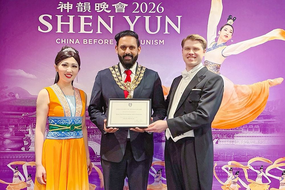 Chiều ngày 26/02/2026, ông Majid Hussain (giữa), Thị trưởng High Wycombe, Anh, đã trao chứng thư tuyên dương cho Đoàn Nghệ thuật Biểu diễn Shen Yun tại Nhà hát Wycombe Swan.
